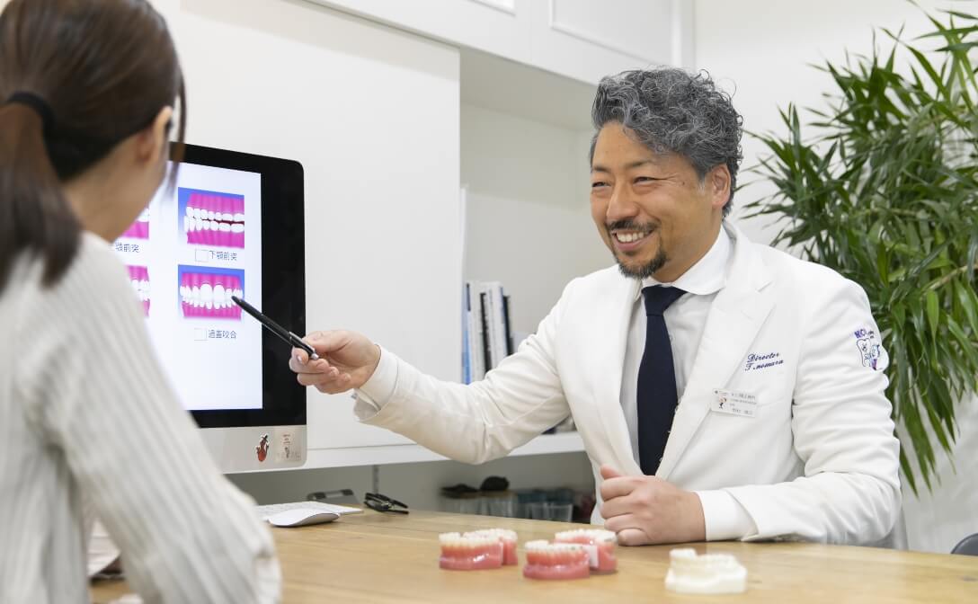 歯並びの状態と治療方針の説明している風景